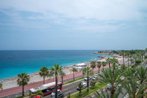 - une vue sur une plage bordée de palmiers et un bus dans l'établissement Le balcon de la baie des Anges, à Nice