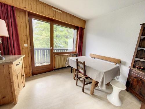 une cuisine avec une table et des chaises et une fenêtre dans l'établissement Caribou Lodge, à Chamonix-Mont-Blanc