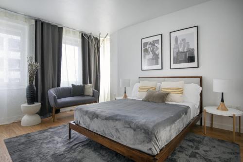 een slaapkamer met een groot bed en een stoel bij Beautiful 2BD Apartment near Times Square in New York