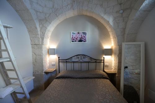 una camera con un letto in una parete in pietra di Trullo A Casedd ad Alberobello