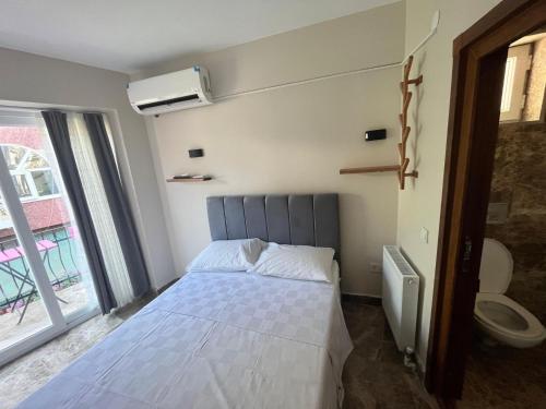 a small bedroom with a bed and a window at Ada Antik 2 in Adalar