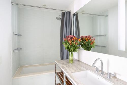a bathroom with a sink and a shower with flowers at Modern 2BD in Midtown with Washer and Dryer in-unit in New York