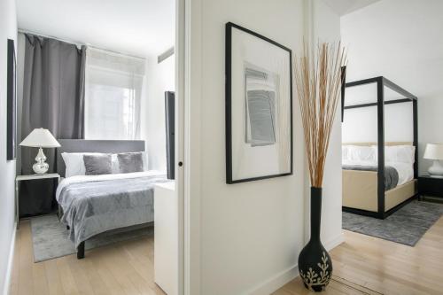 a bedroom with a bed and a vase on the floor at Modern 2BD in Midtown with Washer and Dryer in-unit in New York