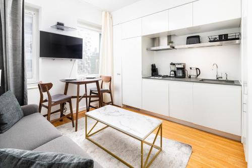 uma sala de estar com um sofá e uma mesa em Gorgeous One-Bedroom on 35th floor in Midtown em Nova York