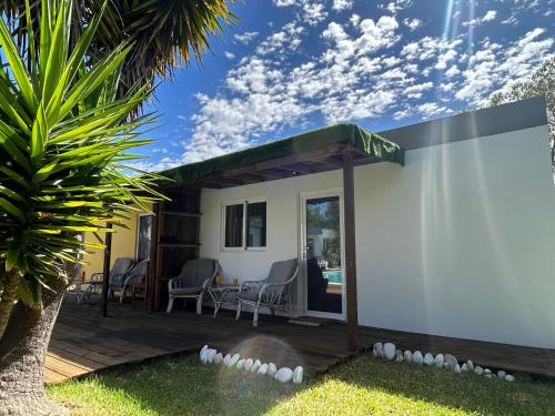 a small white house with a deck with a palm tree at Quinta da Joia in Silves
