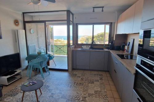 une cuisine avec une table et une cuisine avec vue dans l'établissement T2 au calme-vue mer et baie de Collioure-Garage, à Collioure