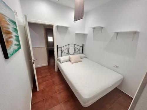 a small bedroom with a white bed in a room at Chalet Empul El Béjar in Chiclana de la Frontera
