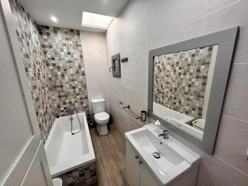 a bathroom with a sink and a toilet and a mirror at Chalet Empul El Béjar in Chiclana de la Frontera