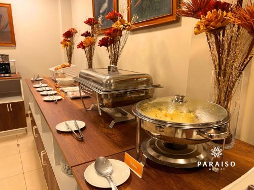 a kitchen with a buffet with a table with flowers at Hoteles Paraiso CHICLAYO in Chiclayo