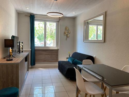een woonkamer met een bank en een tafel bij F2 Résidence Eurotel n°1 avec vue sur le Cher, Centre - Ville in Montluçon