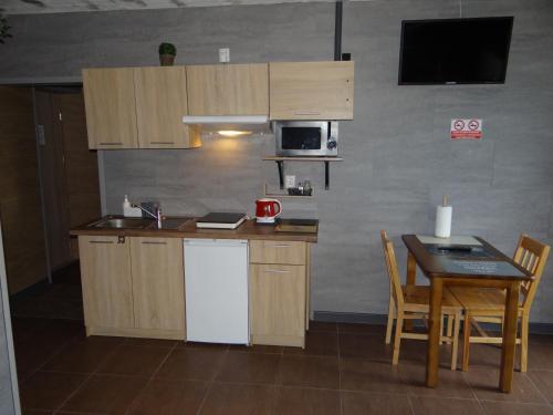a kitchen with a white refrigerator and a table at Hotel Apartamenty 72 in Płock