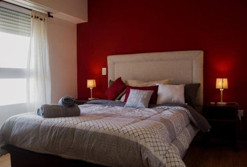 Schlafzimmer mit einem großen Bett mit roten Wänden in der Unterkunft Comodo apartamento en Boedo in Buenos Aires