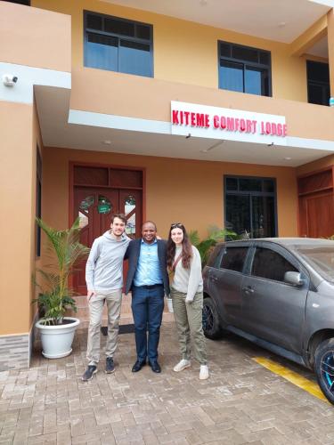 a group of three people standing in front of a car at Kiteme Comfort Lodge in Arusha