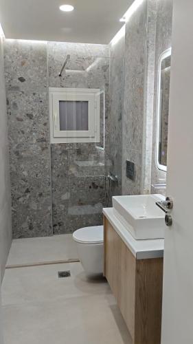 a bathroom with a sink and a toilet at inas apartments 2 in Lefkímmi