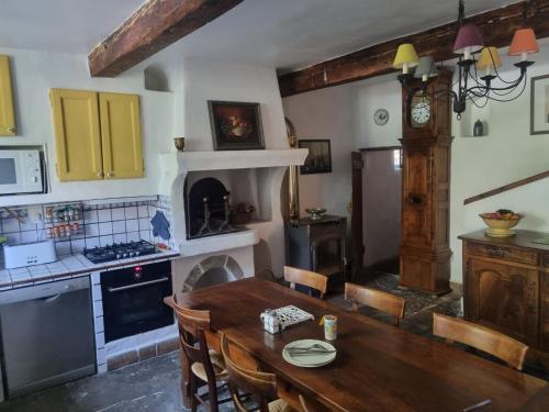 une cuisine avec une table en bois et une salle à manger dans l'établissement Grand Mas Provençal avec jacuzzi, à Sisteron