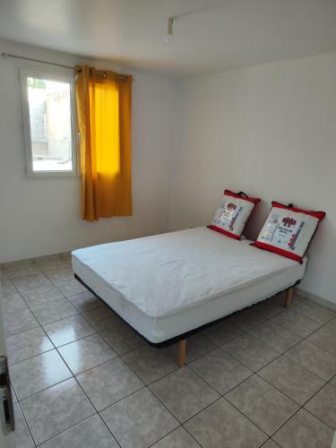 Poggi的住宿－Appartement 2 Pièces Vue Montagne Proximités Grandes Surfaces，一间卧室配有一张带两个枕头的床
