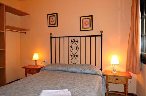 レスカラにあるPunta Romana C303のベッドルーム1室(ベッド1台、ランプ2つ、テーブル2台付)
