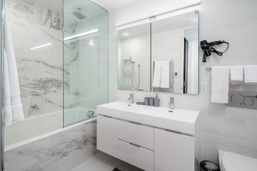 uma casa de banho branca com um lavatório e um chuveiro em Perfectly located 2BD Penthouse in Chelsea em Nova Iorque