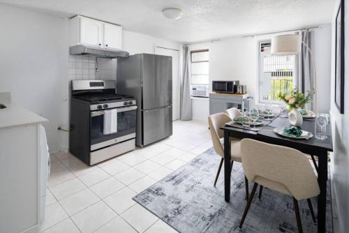 uma cozinha com uma mesa de jantar com cadeiras e um fogão em Stylish One-Bedroom with In-unit Laundry in East Village em Nova York