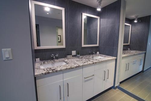 a bathroom with two sinks and two mirrors at Hotel Edison Times Square in New York