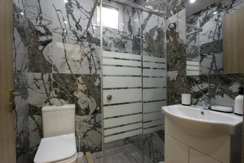 een badkamer met een toilet en een wastafel bij Vila SHAKAJ in Sarandë