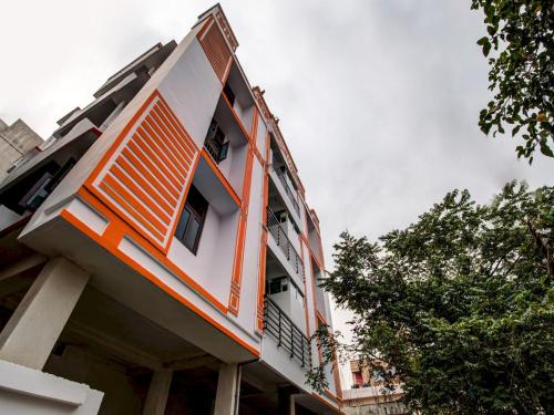 an orange and white building with trees in the foreground at Super Hotel O Rajbanshi Nagar in Patna
