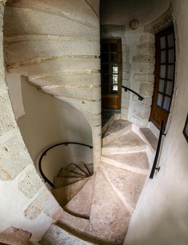 - un escalier en colimaçon dans un ancien bâtiment en pierre dans l'établissement Maison Forte Perreuse, à Treigny