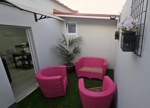 two pink chairs and a table in a room at Apartamentos GARAKOTA in Telde