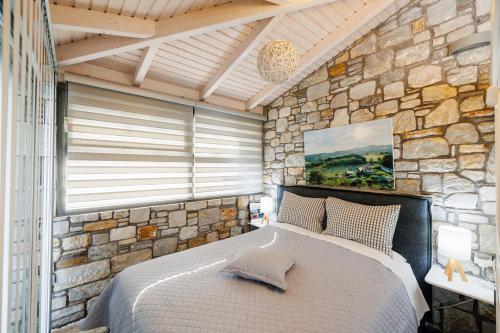 a bedroom with a large bed in a stone wall at Hacienda Verde in Serres