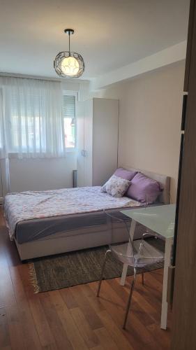 Stan na dan Loznica في لوزنيكا: غرفة نوم بسرير وطاولة زجاجية