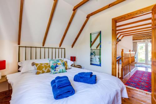 a bedroom with a white bed with blue towels on it at Baywatch Sands in Wadebridge