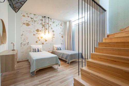 a room with two beds and a stair case at Topos Maisonettes by RentalsPro - Kalives Halkidiki in Kalivia Poligirou