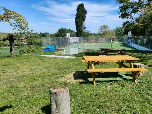 a picnic table in a park with a tennis court at Le Pitstop in Alan