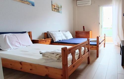 a bedroom with two twin beds and a window at Long Beach Apartment in Makrygialos