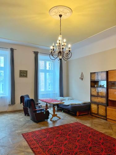 a living room with a chandelier and a table and chairs at Old Town Rooms Wielopole in Krakow