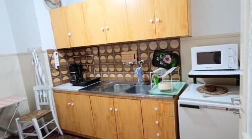 uma cozinha com um lavatório e um micro-ondas em Long Beach Apartment em Makrýgialos