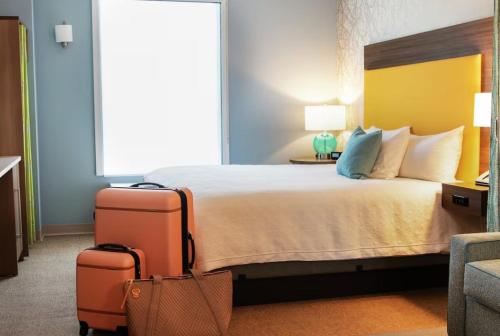 a hotel room with a bed with two suitcases at Home2 Suites By Hilton Dalton in Dalton