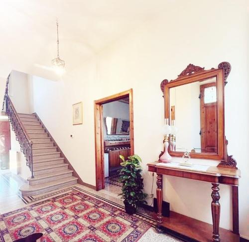 a bathroom with a sink and a mirror and a staircase at Bed and Breakfast Villa Adelina in Lucca