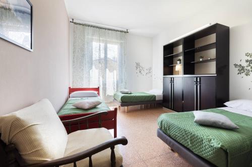 a bedroom with two beds and a chair in it at We Home - SANLUCA57, Bologna in Bologna
