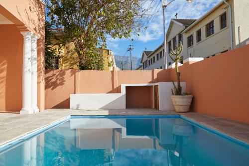a swimming pool in a backyard with a house at City Club Guesthouse in Cape Town