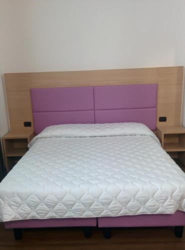 a purple and white bed in a bedroom at Hotel Esperanza in Florence