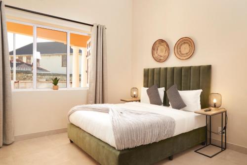 Cape Town的住宿－City Club Guesthouse，一间卧室设有一张大床和一个窗户。