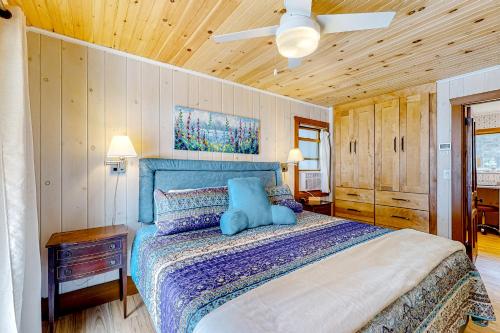 a bedroom with a blue bed with a ceiling fan at Shore Acres in Isle la Motte
