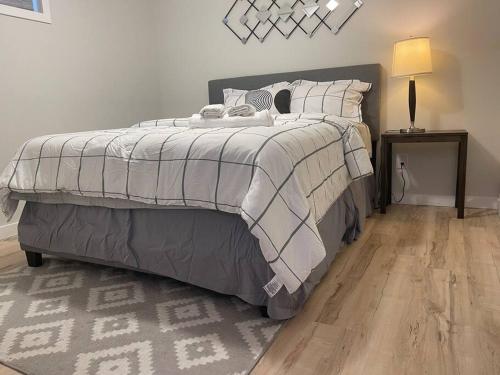 a bedroom with a large bed and a wooden floor at Fully Furnished CozyTwo Bedroom in Winnipeg