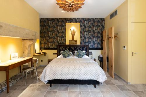 a bedroom with a bed and a table and a desk at Domaine de Saulon in Saulon-la-Rue