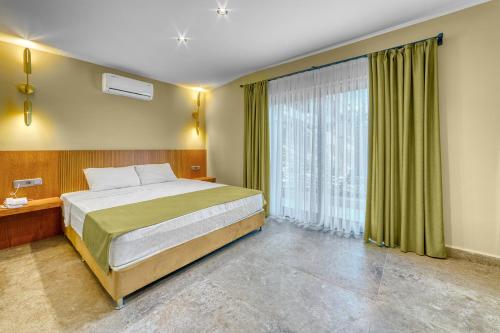 een slaapkamer met een bed en een groot raam bij Yeniacun Apart Hotel in Alanya