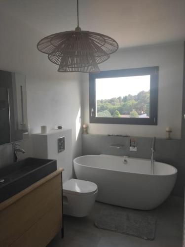 une salle de bain avec baignoire et toilettes et une fenêtre dans l'établissement Villa spacieuse avec piscine en Provence, à Ventabren