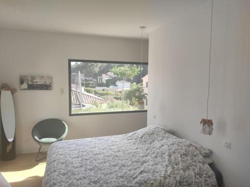 une chambre avec un lit, une chaise et une fenêtre dans l'établissement Villa spacieuse avec piscine en Provence, à Ventabren