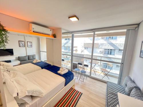 a bedroom with a large bed and a balcony at Moderno apto com piscina rua Augusta e Frei caneca in Sao Paulo