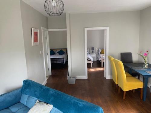 a living room with a blue couch and a dining room at Fort Mews in Ballina